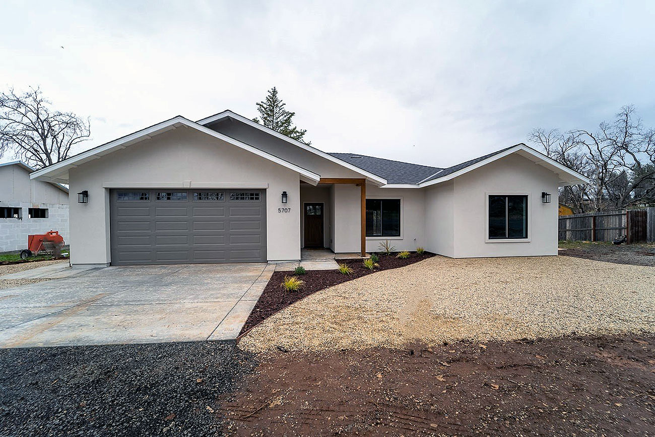 Modern single-story home with garage and gravel yard