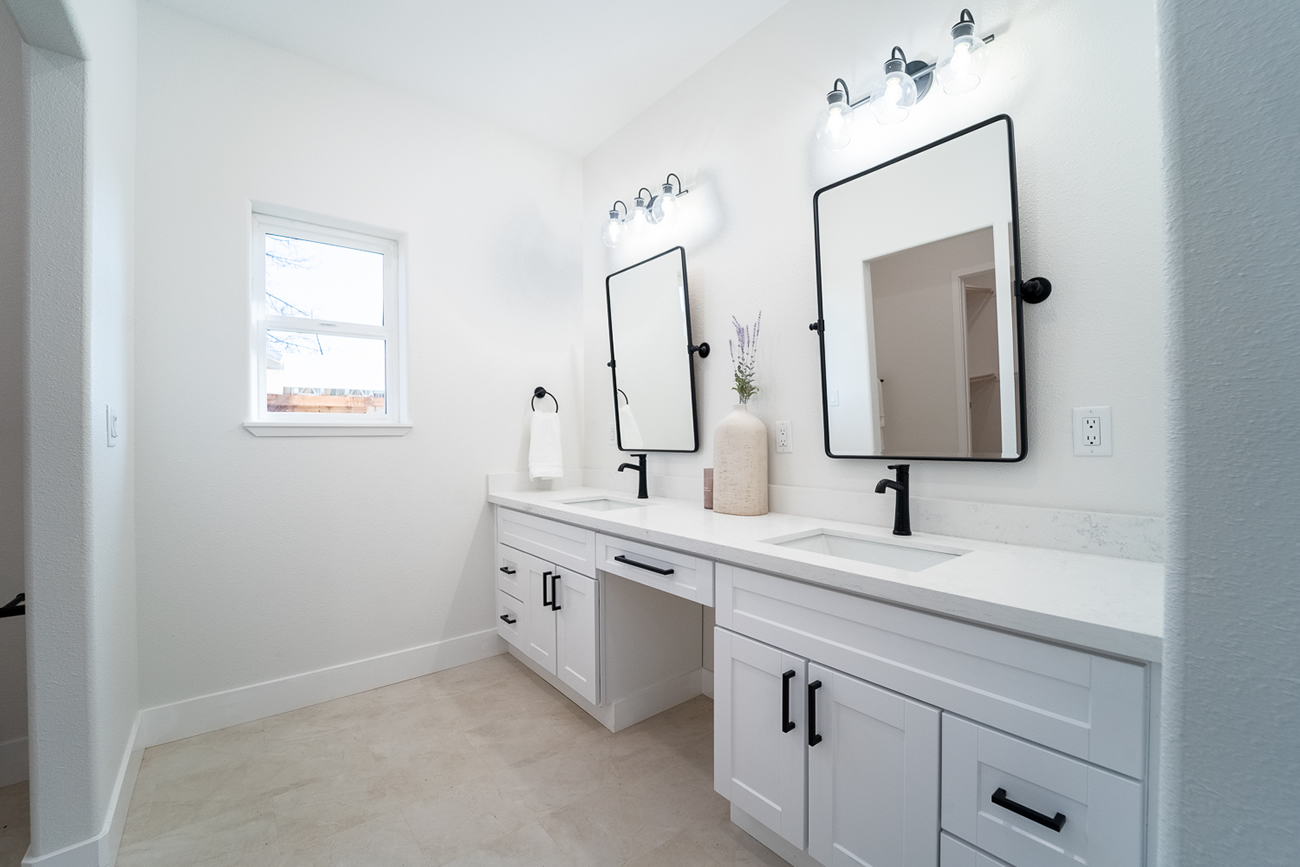 Double vanity bathroom with white cabinets and black fixtures