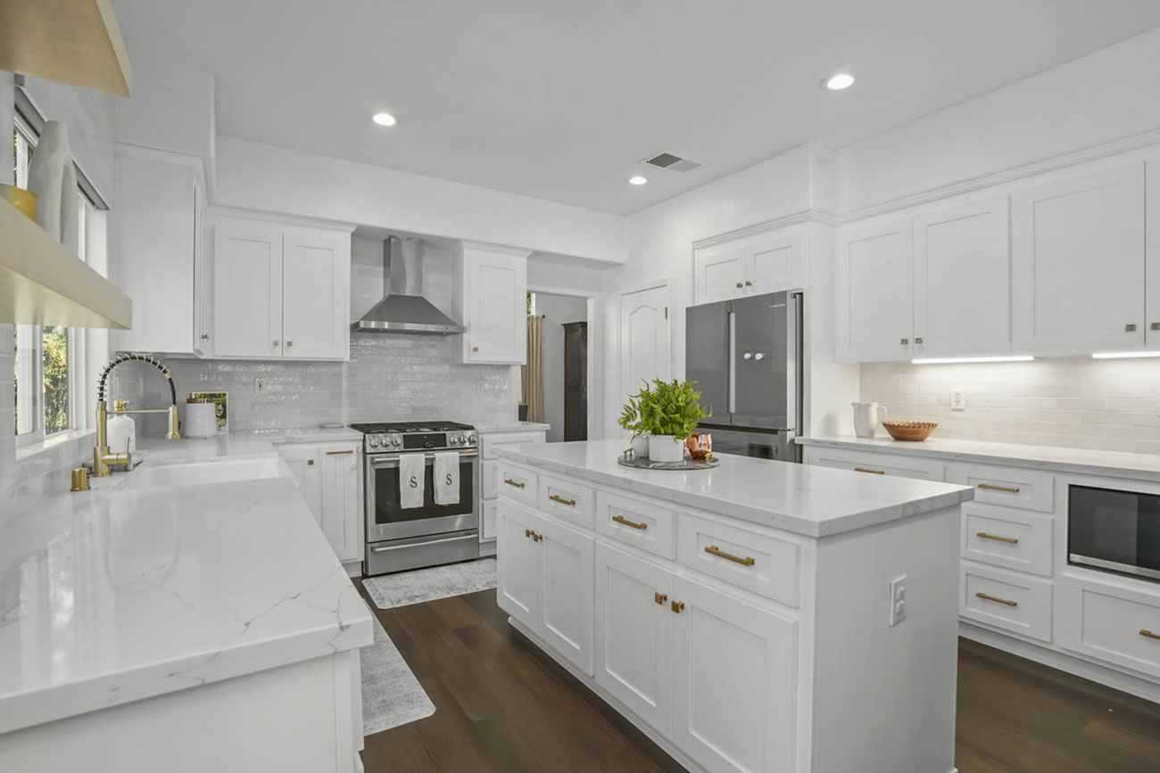 White kitchen with large island and stainless appliances